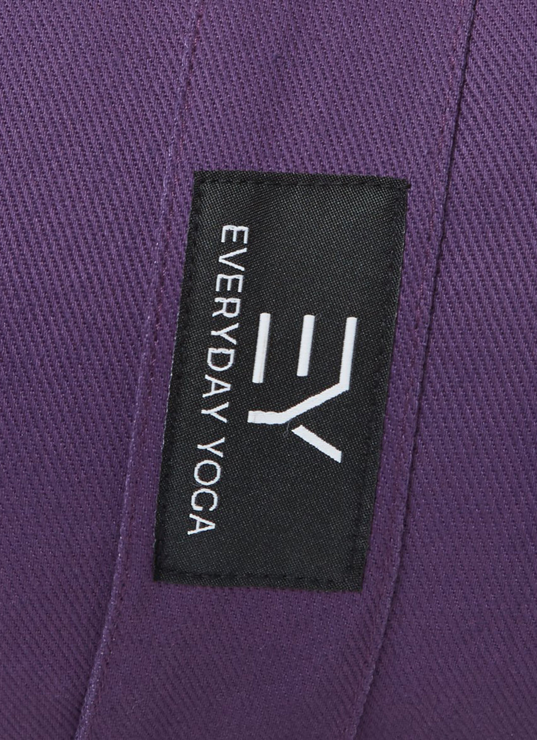 Plum-colored yoga bolster by Everyday Yoga, designed for enhancing yoga practice. Features a durable fabric with a black label displaying the Everyday Yoga logo. Ideal for supporting various yoga poses and improving comfort during sessions.
