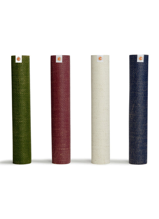 Four rolled yoga mats by Complete Unity in green, red, cream, and blue are displayed vertically. These high-quality mats are designed for yoga enthusiasts, offering durability and comfort for various practices.